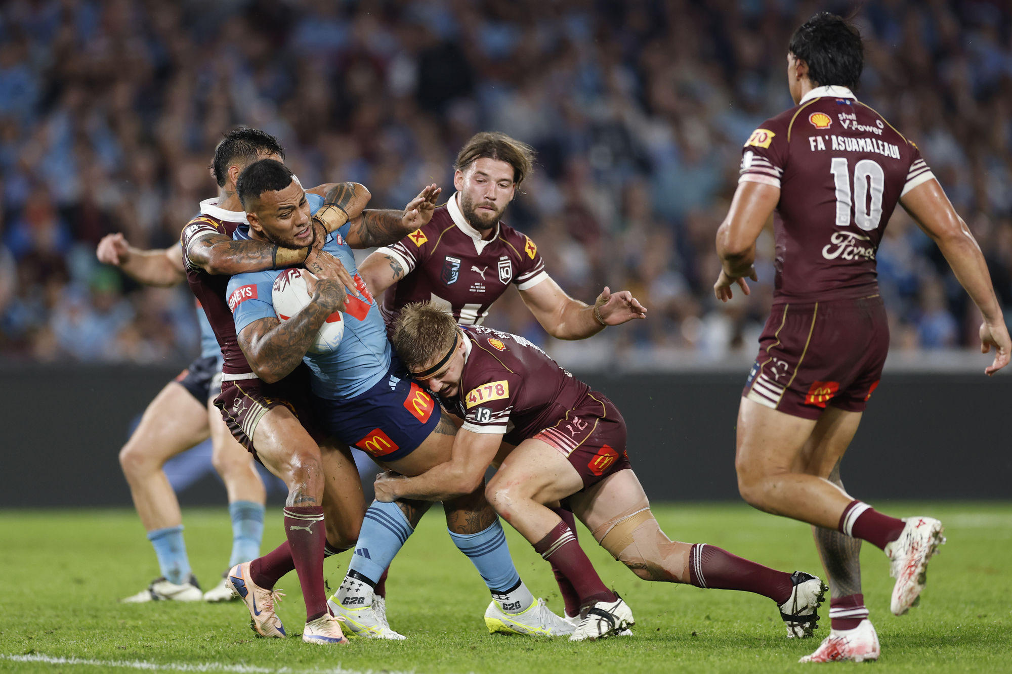 The Blues’ Addin Fonua-Blake is tackled by Maroons players during the first State of Origin game of 2026.